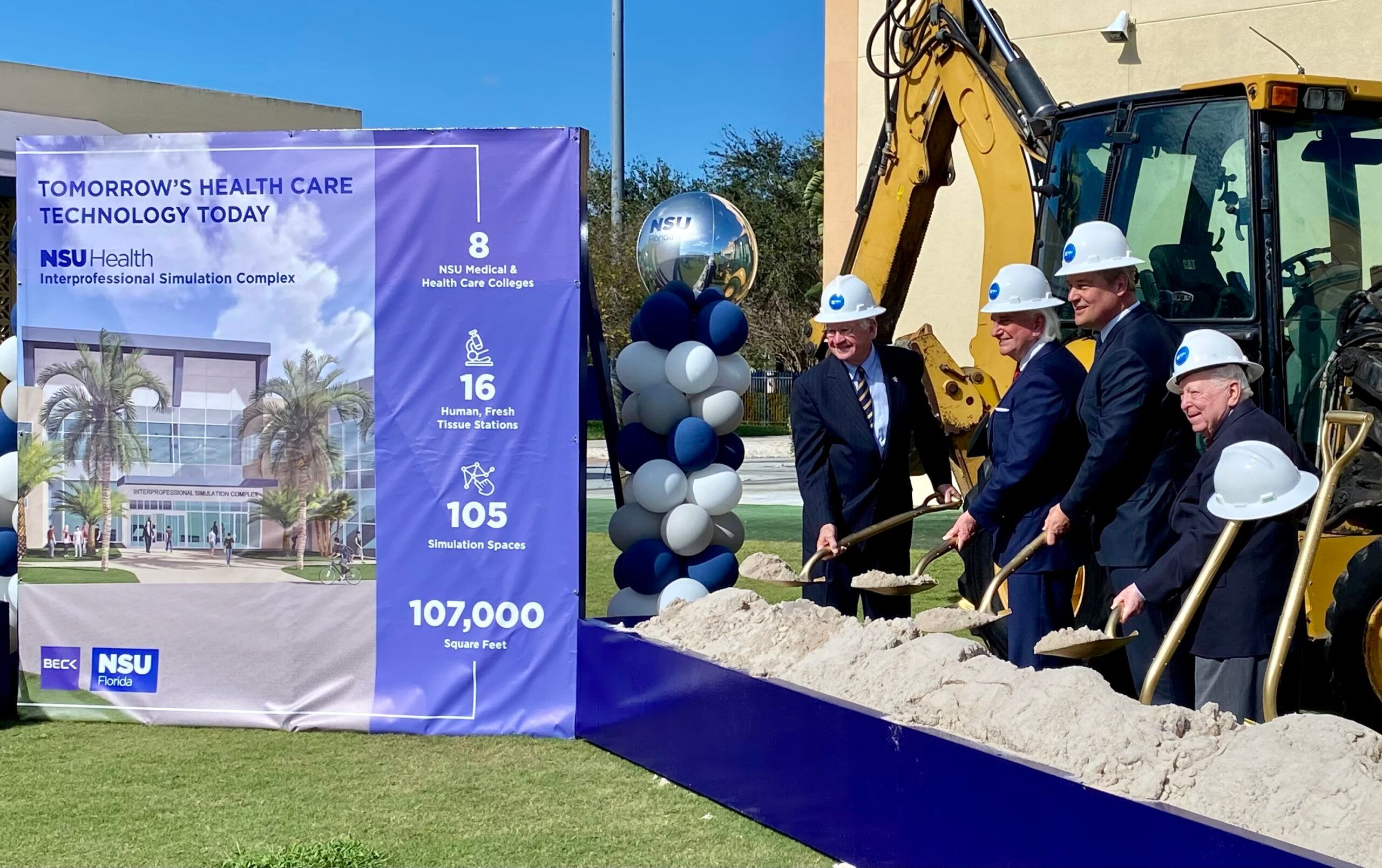 Ballinger Associates holding shovels with sand at Nova Southeastern University