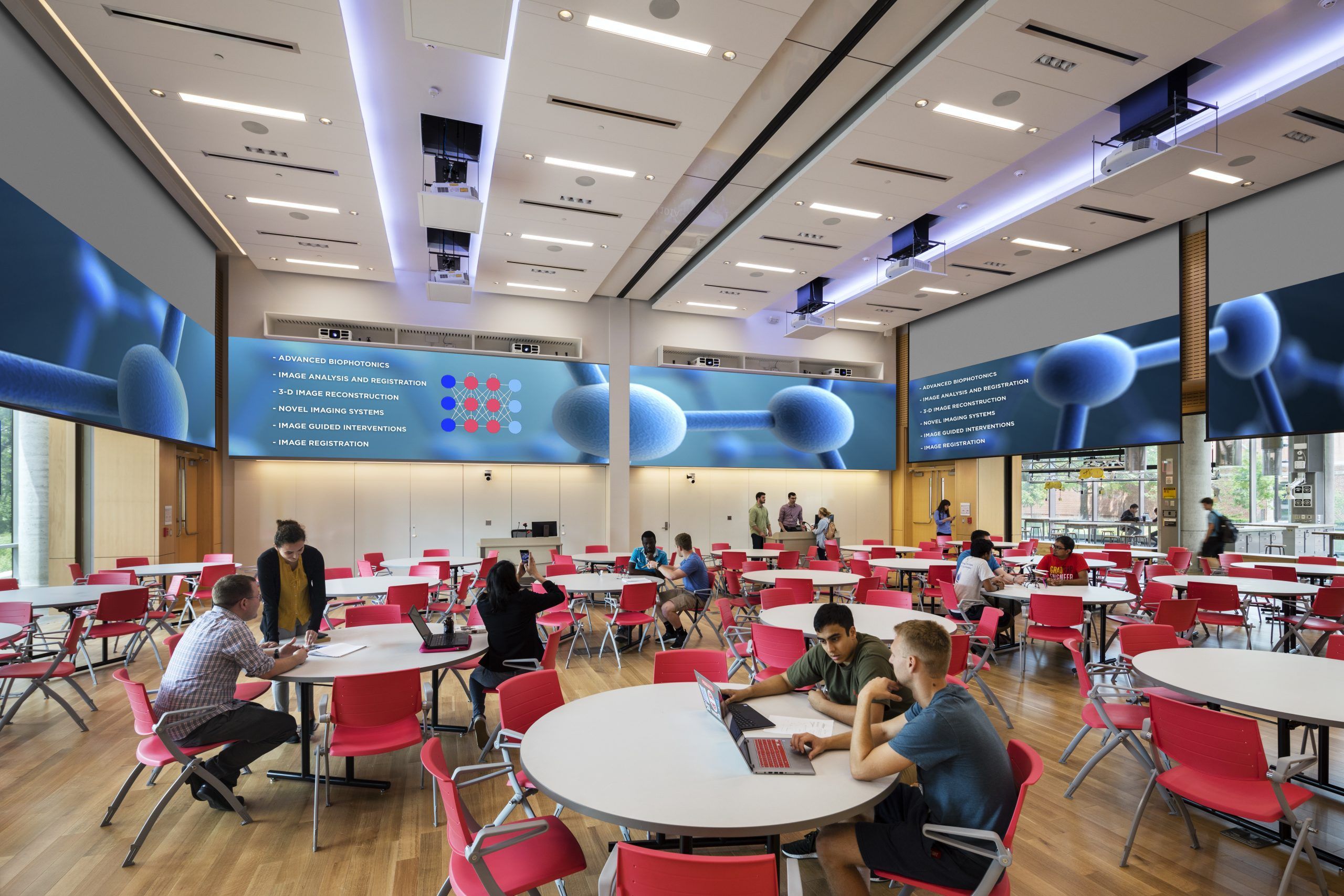 Flexible classroom space with round desks, overhead projection, and natural light